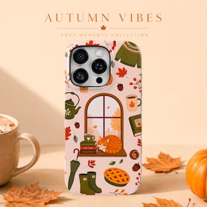 May include: A phone case with a light pink background featuring an autumn-themed pattern of a cat sleeping on a windowsill, a green sweater, a teapot, a mug, books, an umbrella, rain boots, a pie, acorns, and leaves, with the text AUTUMN VIBES.