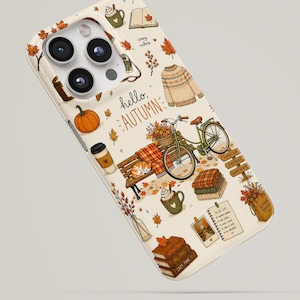 May include: A cream-colored phone case featuring an autumn-themed pattern with a bicycle, a park bench, a pumpkin, a sweater, stacks of books, a coffee cup, and falling leaves. The text "hello, AUTUMN" is printed in the center of the design.
