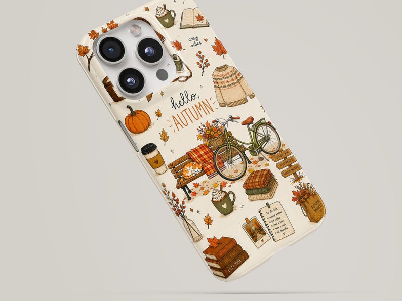 May include: A cream-colored phone case featuring an autumn-themed pattern with a bicycle, a park bench, a pumpkin, a sweater, stacks of books, a coffee cup, and falling leaves. The text "hello, AUTUMN" is printed in the center of the design.