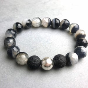 Könnte beinhalten: Ein Armband aus schwarzen und weißen Achatperlen mit schwarzen Lavasteinen und silbernen Perlen.
