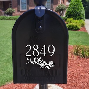 May include: Black mailbox with a white floral design and the number 2849.