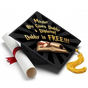 May include: Black graduation cap with gold tassel, featuring the text "Master Has Given Dobby a Diploma! Dobby is FREE!!!" on the top. A rolled diploma with a red ribbon and a book are also present.