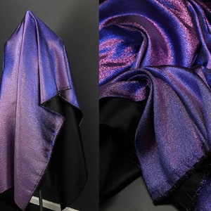 May include: A shimmering iridescent fabric in shades of purple and blue. The fabric has a subtle sparkle and a smooth, silky texture.