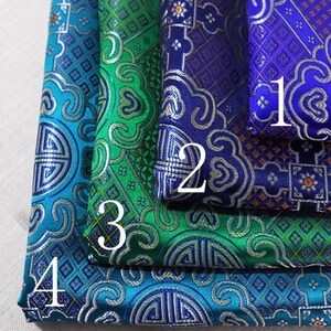 May include: Four pieces of fabric with different patterns. The top fabric is blue with a silver design, the second fabric is blue and orange with a silver design, the third fabric is green with a silver design, and the bottom fabric is blue with a silver design. The fabrics are numbered 1 through 4.