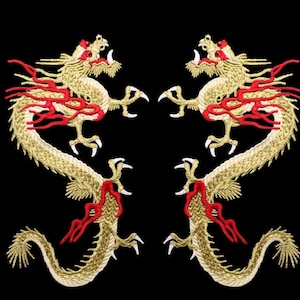 May include: Two gold embroidered dragons facing each other with red flames. The dragons are on a black background.