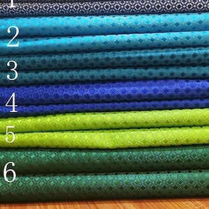 Puede incluir: Seis muestras de tela con un patrón de diamante. Las muestras están dispuestas en una pila de arriba a abajo, con la muestra superior de color azul marino, seguida de turquesa, azul, azul oscuro, verde lima y verde bosque.