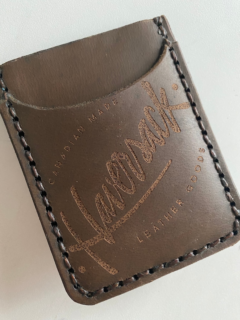 May include: A brown leather wallet with a stitched edge and the text "Havelock Leather Goods" and "Canadian Made" embossed on the front.