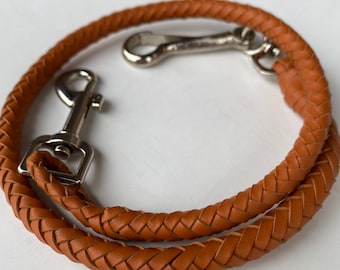 May include: A brown leather braided strap with two silver swivel clasps. The strap is approximately 18 inches long.