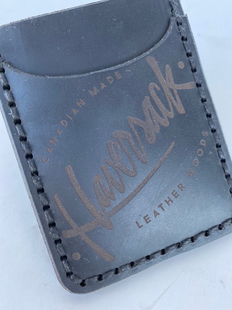 May include: Black leather card holder with a stitched edge and the text "Havensak: Leather Goods Canadian Made" embossed in gold.