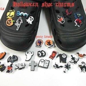 May include: A collection of Halloween-themed shoe charms featuring ghosts, pumpkins, bats, skeletons, and text like "Boo" and "Trick or Treat." The charms are displayed on and around two black clogs, with text overlays reading Halloween shoe charms, bracelets, gift bags, and party favors.