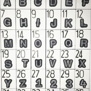 Puede incluir: Una cuadr&iacute;cula de cuadrados blancos con contornos negros, cada uno con un n&uacute;mero y una letra o n&uacute;mero. Las letras y los n&uacute;meros son de purpurina plateada. El texto "silver glitter" y "Page 97" est&aacute; en la parte superior.