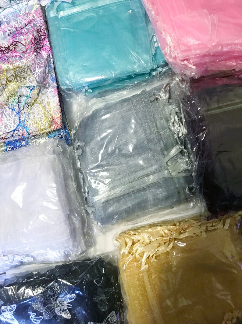 Puede incluir: Un surtido de cuadrados de tela transparente de colores, empaquetados en pl&aacute;stico transparente. Los colores incluyen rosa, azul, blanco, gris, negro y dorado. Algunas telas tienen dise&ntilde;os decorativos, como ramas o mariposas.