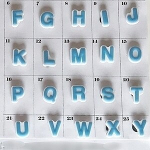 Puede incluir: Una hoja de letras del alfabeto, cada una de color azul claro con un borde blanco. Las letras est&aacute;n dispuestas en una cuadr&iacute;cula, con el texto "P&aacute;gina 83" en la parte superior e inferior. Las letras son de la A a la Y, con la letra Z en la parte inferior.