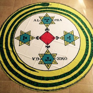 May include: A white circular tapestry with a yellow and green border. The center of the tapestry features a snake curled around a circle with four stars and a red diamond. The text "ALPHA" and "OME-GA" are written in Hebrew.