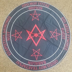 May include: A black circular cloth with a white border and red pentagrams. The text around the border reads "PRO MOU IYGGES, THIERION, EPIRISTERIA DAIMONES, NUIT, EPI DEXIA SYNOCHEZ, HADIT, OPISOU MOU TELETARXAI, BABALON".