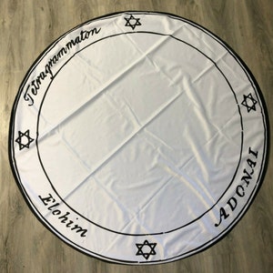 May include: White circular cloth with a black border and black text. The text reads "Tetragrammaton", "Elohim", and "Adonai". There are five black six-pointed stars around the border.