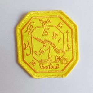 May include: Yellow embroidered patch with a unicorn and the text "Ugly But Delicious" in a circular design.