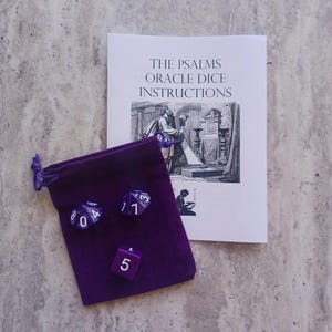 Könnte beinhalten: Ein violetter Samtbeutel mit drei violetten Würfeln mit weißen Zahlen. Die Würfel zeigen die Zahlen 4, 1, 3, 5. Der Beutel liegt neben einem weißen Heft mit dem Text "The Psalms Oracle Dice Instructions".