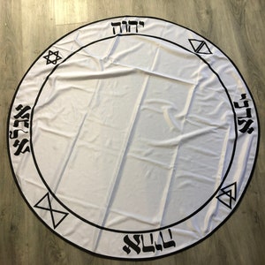 May include: White circular cloth with a black border and Hebrew text around the edge. The text includes the words "L'CHAIM" and "SHALOM".