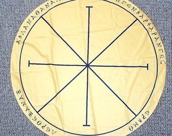 May include: A yellow circular cloth with a black eight-pointed star design. The cloth has black text around the edge, including the words "ABLANOANAALBA" and "CEECENTENBAP&APANTEC".