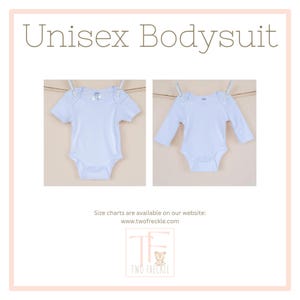 The image is a collage of two photographs of a white unisex baby bodysuit hanging on a clothesline. The text above the images reads "Unisex Bodysuit" and below the images, there is a note that says "Size charts are available on our website: www.twofreckle.com".