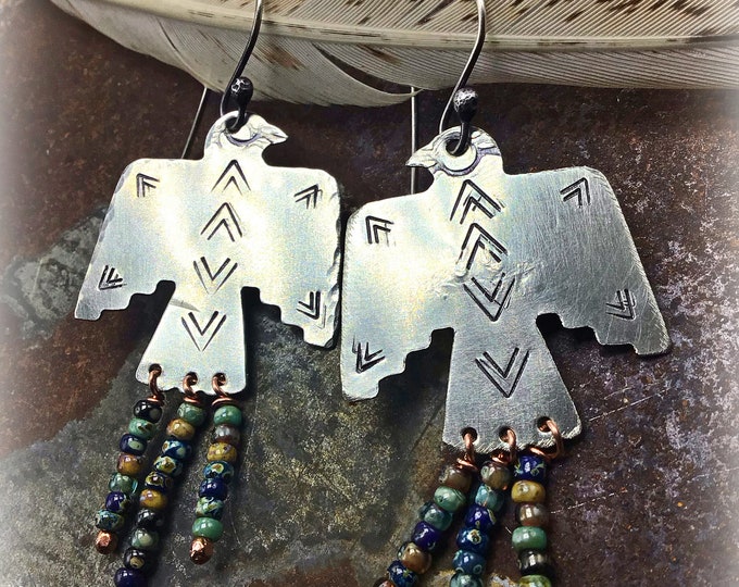 Beaded thunderbird earrings by Weathered Soul, nickel silver embossed with design details