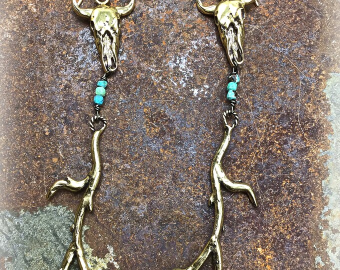 Bronze long beauties, rustic tree branches with a steer skull on top with tiny turquoise sandwiched between