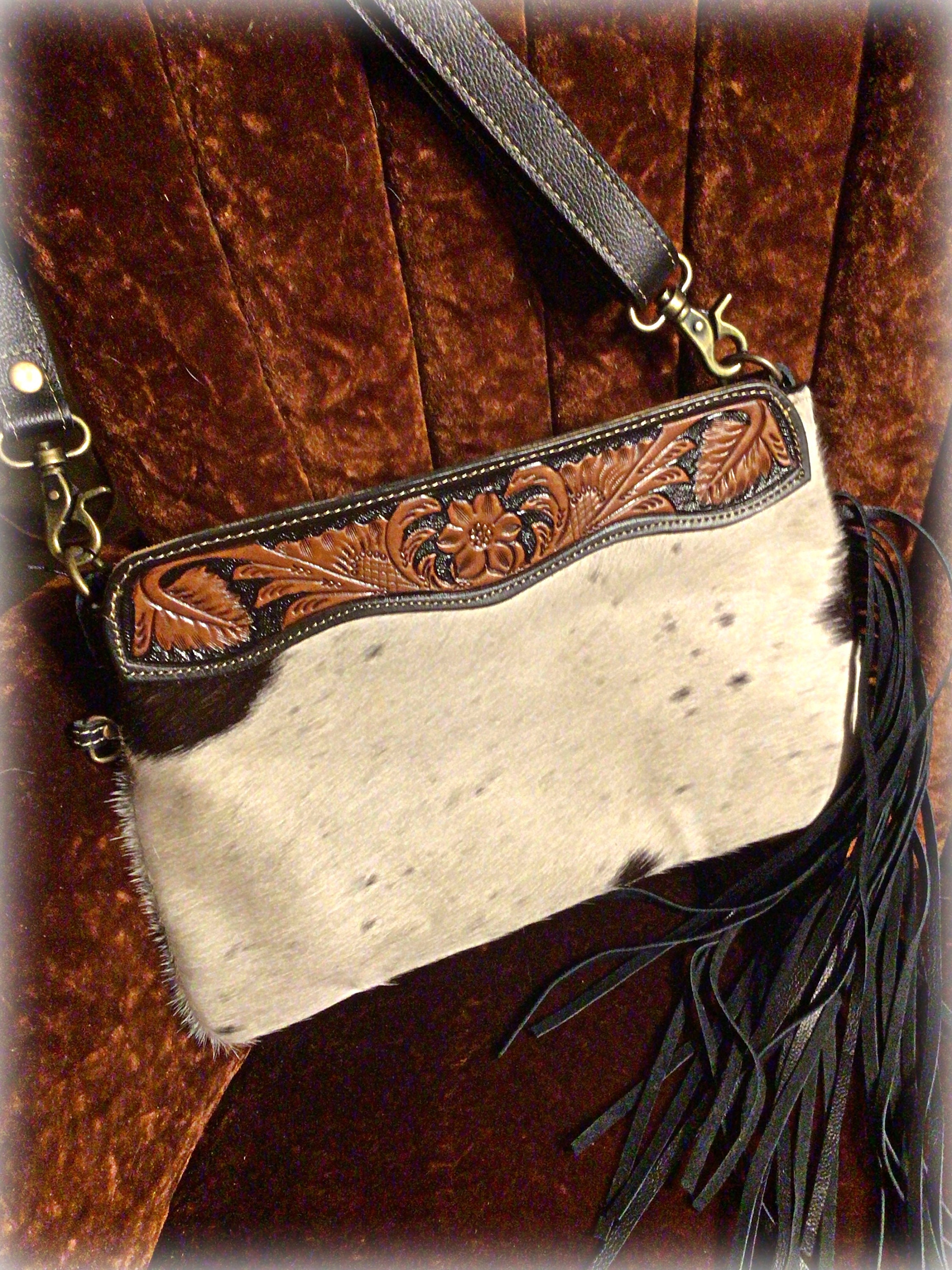 Sweet larger clutch style tooled leather hair on hide bag with black fringe down one side