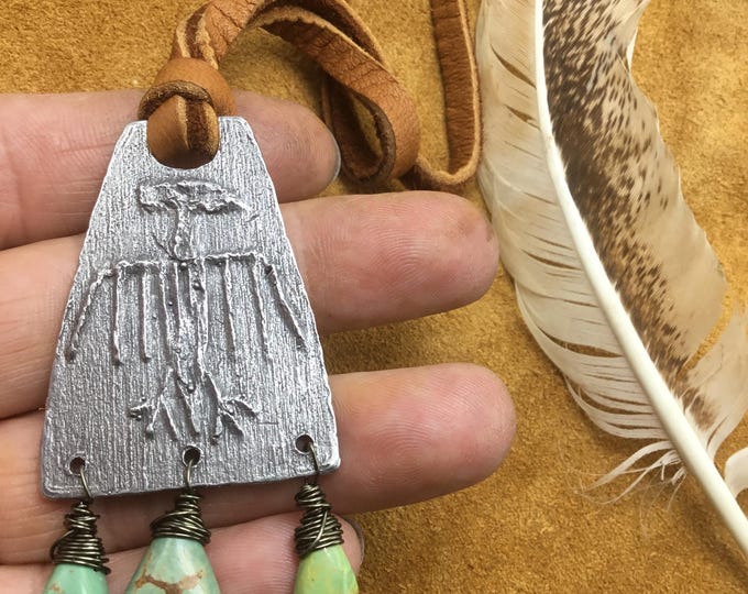 Large statement primitive Thunderbird pendant on Elk leather with drop turquoise wire wrapped at bottom. Easy over the head styling