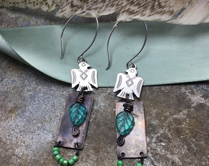 Artistic thunderbird earrings with sterling and copper beaded with Swarovski leaves dangling down