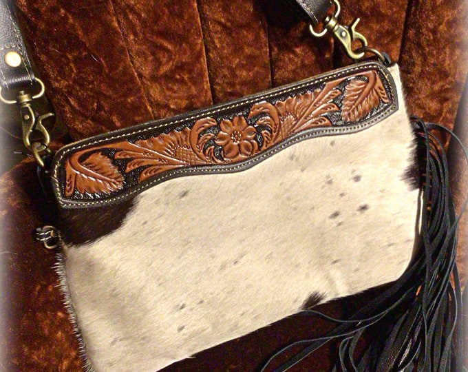 Sweet larger clutch style tooled leather hair on hide bag with black fringe down one side,