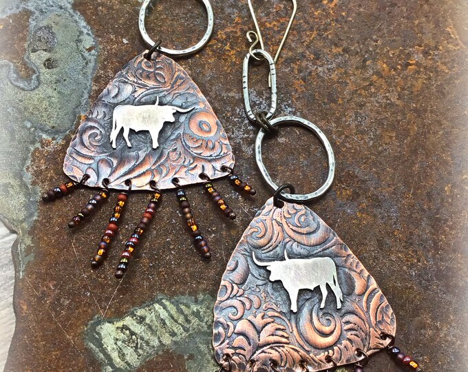 Let’s get western earrings by Weathered Soul, longhorns on tooled looking oxidized copper under sterling hoops