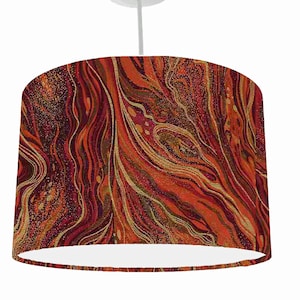 May include: A red, orange and gold patterned lampshade with a white interior. The pattern resembles swirling marble.