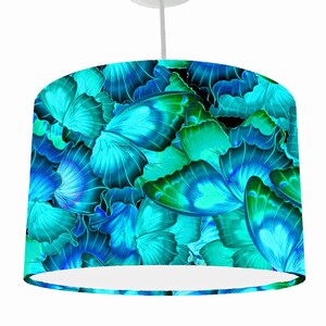 May include: A blue and green patterned lampshade featuring a design of butterfly wings.