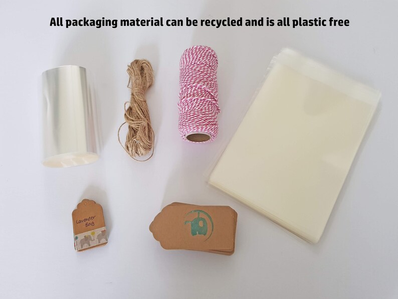 May include: A collection of packaging materials for gifts, including clear cellophane wrap, twine, brown paper gift tags, and a small bag. The text "Lavender Bag" is printed on one of the tags. All packaging materials are plastic-free and recyclable.