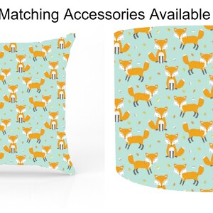 May include: A teal blue throw pillow with a repeating pattern of orange foxes and yellow leaves. The pillow is square and has a white border.