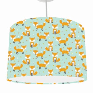 May include: A light blue lampshade with a repeating pattern of orange foxes on a light blue background.
