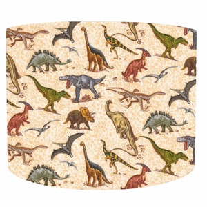 May include: A beige lampshade with a repeating pattern of colorful dinosaurs, including a Tyrannosaurus Rex, Triceratops, and Stegosaurus.