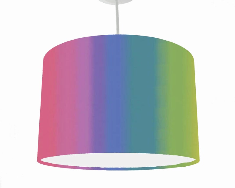 May include: A rainbow ombre lampshade with a white inner lining. The lampshade is a cylinder shape and has a gradient of pink, purple, blue, green, and yellow.