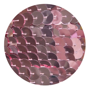 May include: A close-up of a pink sequin fabric. The sequins are arranged in a circular pattern, creating a shimmering effect.