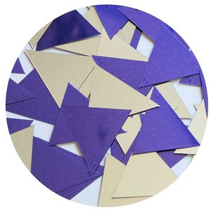 May include: A collection of purple and gold metallic triangle confetti. The confetti is made of a shiny material and has a textured surface.