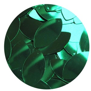 May include: A close-up of a pile of green metallic sequins in the shape of a teardrop. The sequins are shiny and have a slight iridescent quality.