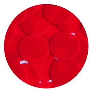 May include: A close-up of a pile of red velvet circles. The circles are arranged in a random pattern and are all the same size.