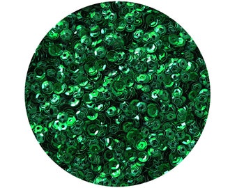 May include: A close-up of a large quantity of green sequins. The sequins are small and round, with a slightly iridescent finish.