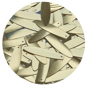 May include: A pile of gold-colored metal sequins in the shape of elongated ovals. The sequins have two small holes at the top.