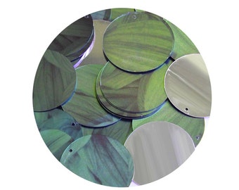 May include: A collection of green and silver round sequins. The green sequins have a textured, leaf-like pattern, while the silver sequins are smooth and reflective. Each sequin has a small hole for sewing or stringing.