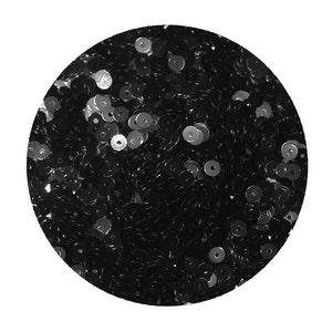 May include: A close-up of a pile of black sequins. The sequins are small and round, and they are arranged in a random pattern.