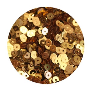 May include: A close-up image of a pile of gold sequins. The sequins are round and have a hole in the center. They are perfect for crafting and decorating.