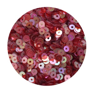 May include: A close-up of a pile of iridescent red sequins. The sequins are round and have a metallic sheen.