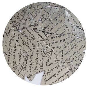 May include: A circular collage of paper cutouts with script text. The cutouts are arranged in a circular pattern, overlapping each other. The text appears to be from a classic literary work, with elegant calligraphy.